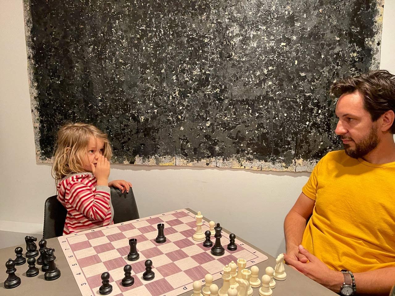 Little girl and adult man plaing chess on Walnut and Maple wood grain mousepad chesssboard.